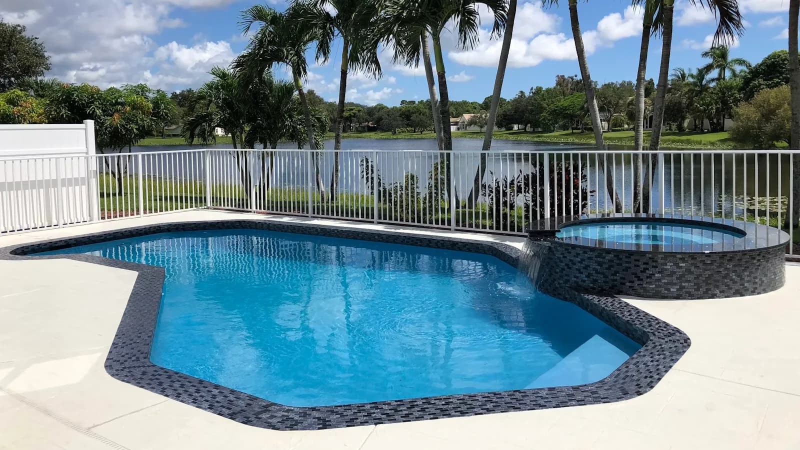 Piscina com água azul ao lado de palmeiras em dia de sol